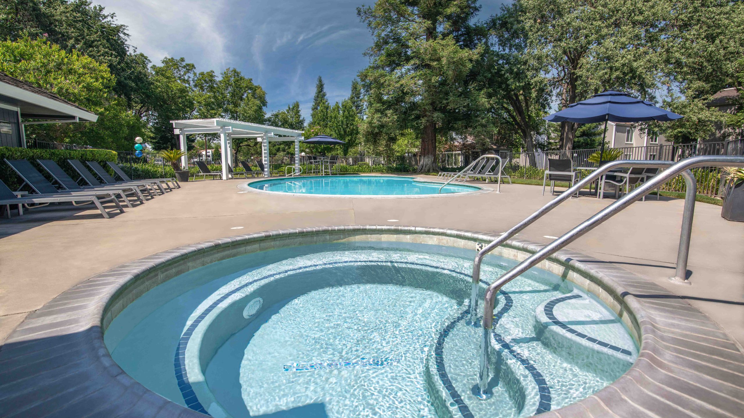The after photograph of the same recreational area vividly demonstrates enhancements, featuring a spectacular sky, reflections in the pool, and visible flames in the fire, creating an inviting and captivating environment that beckons viewers to live here.
